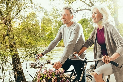 Couple âgé à vélo avec des appareils auditifs