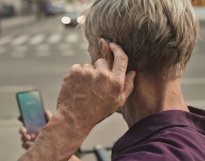 Smartes Hörgerät mit Smartphone verbunden. Erleben Sie Hörstärke.